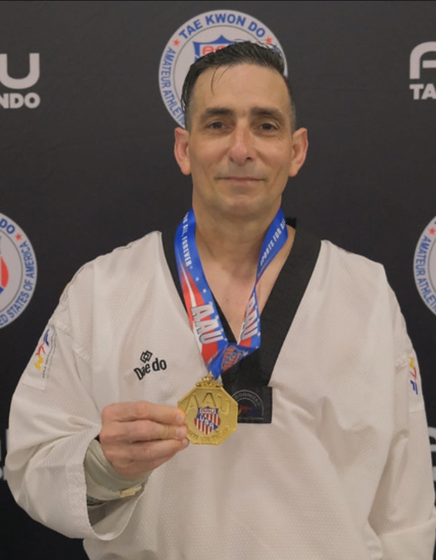 Master Vicente Albuerne - 6th Dan Kukkiwon, 17-year Florida State Champion, 5x National Champion, holding AAU gold medal